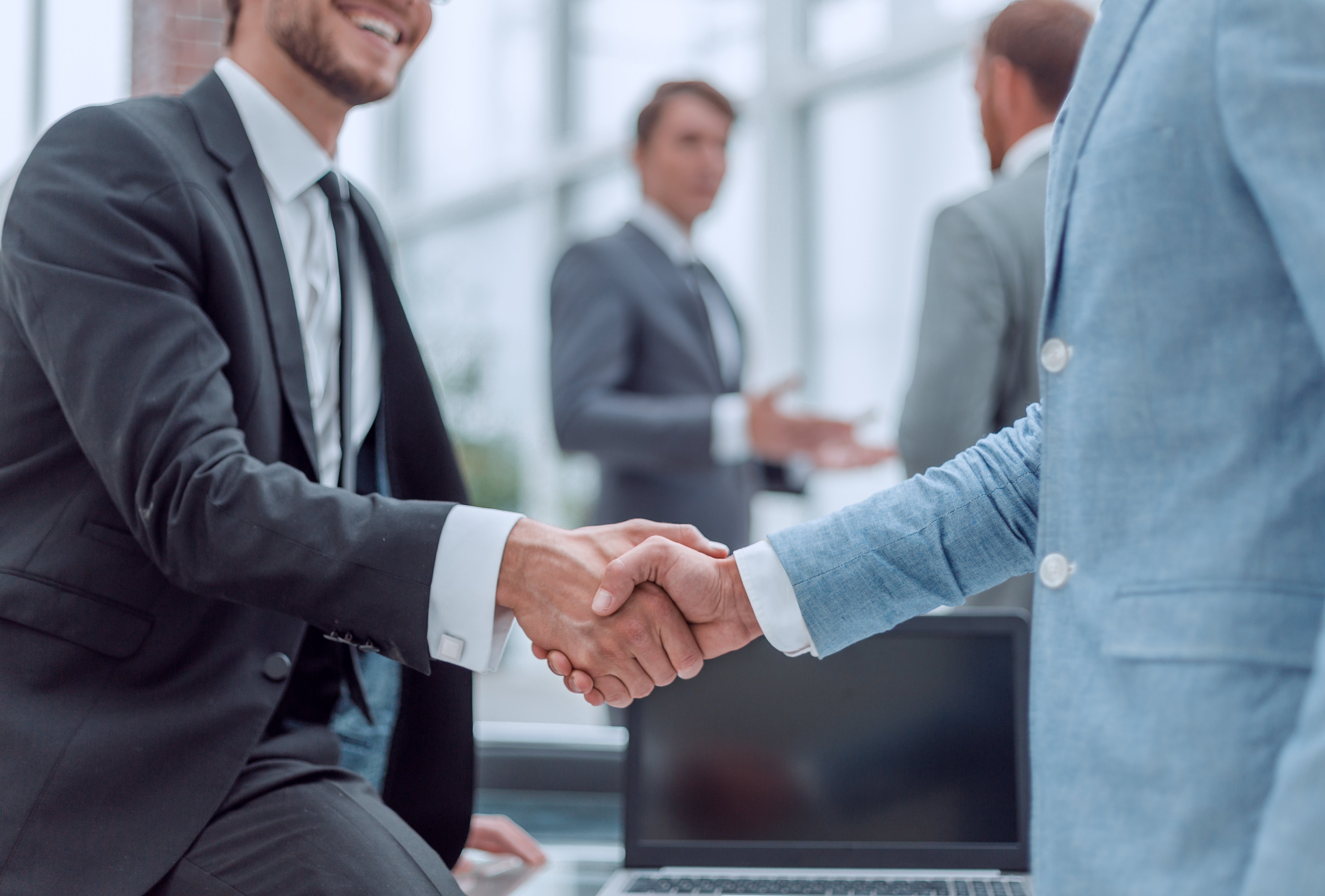 Businessmen shaking hands in office