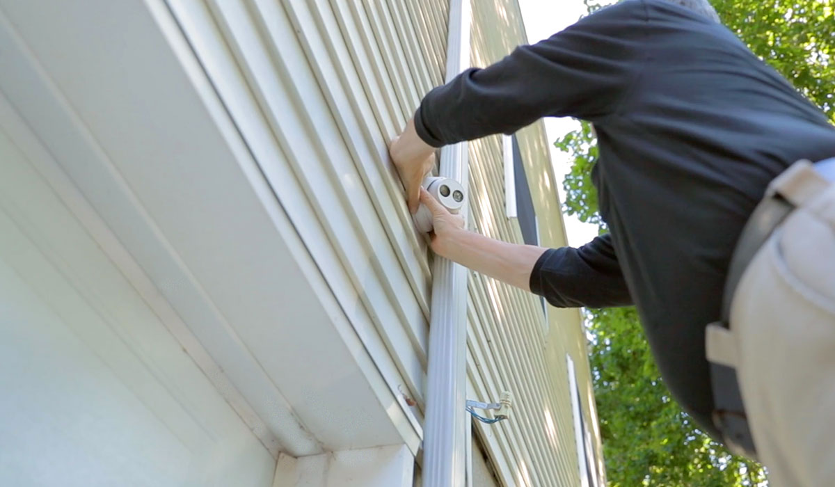 general security employee installing outdoor security camera