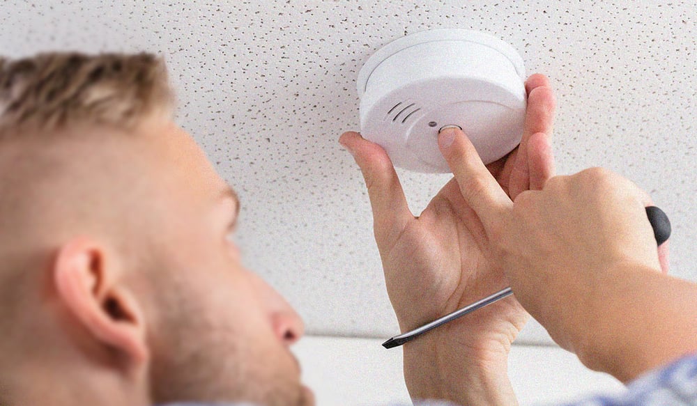 man changing out carbon monoxide detector