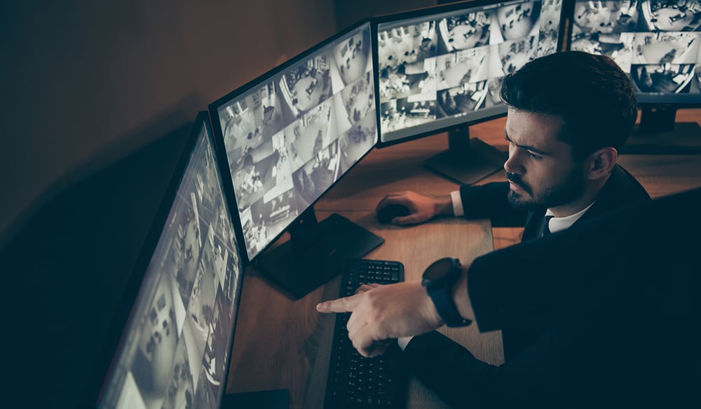 Man looking at security cameras