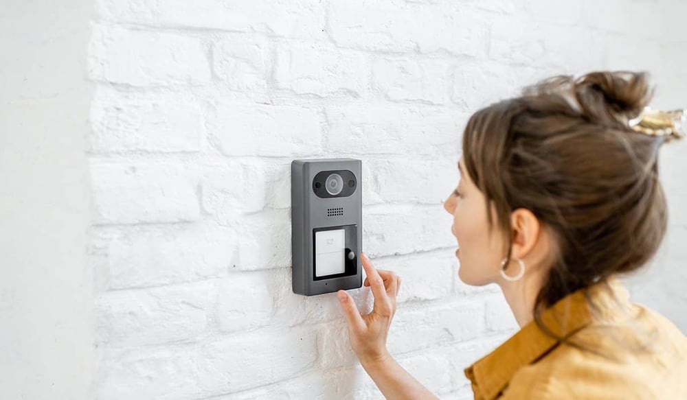 Woman using video doorbell to speak to friend