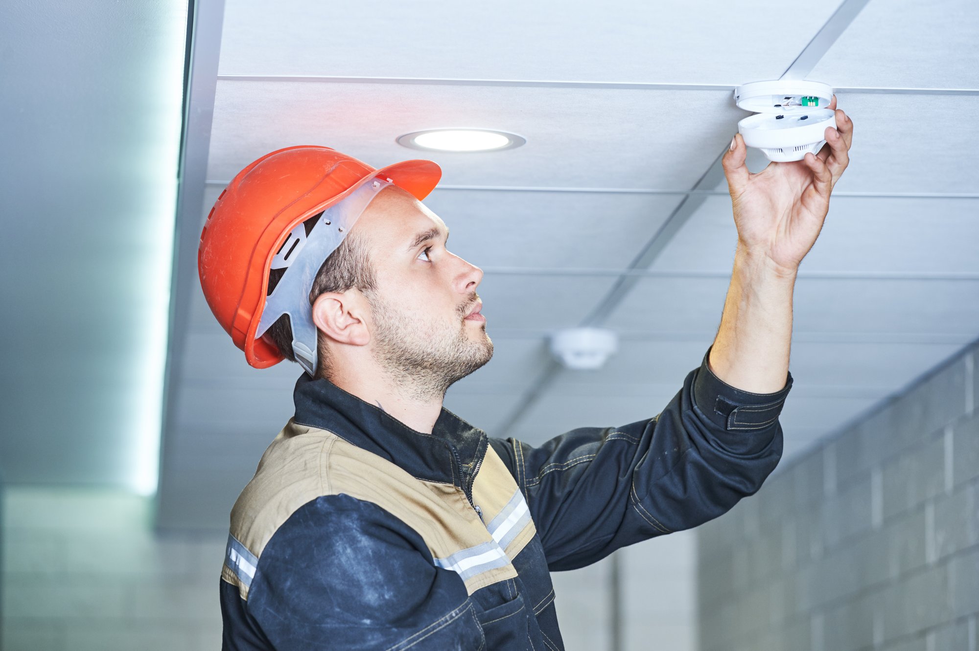 Worker fixing smoke detector