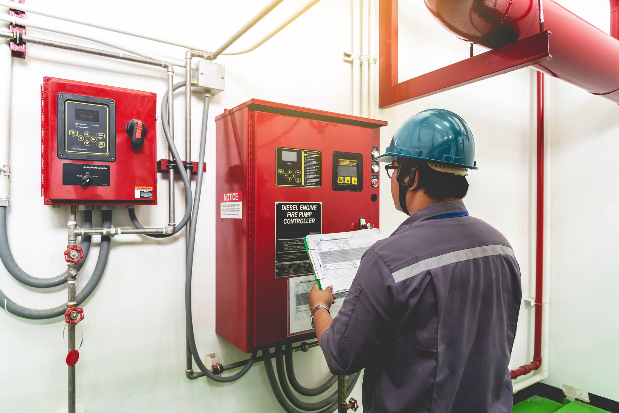 Worker looking at fire system control panel