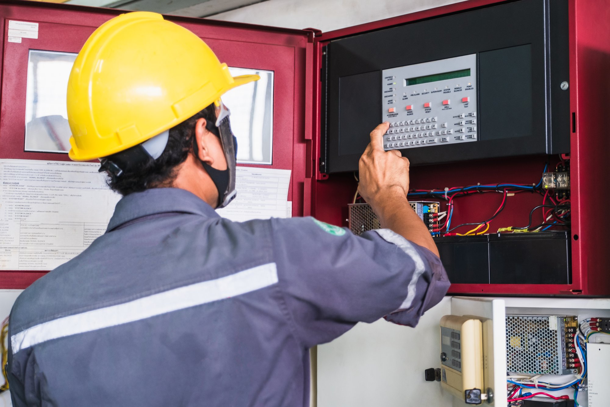 Worker technician working on fire alarm system